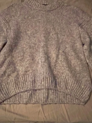 Gråmelerad stickad polotröja - Fin stickad tröja från Vero Moda! Mysig och grovstickad i gråmelerad ton med inslag av beige och blått. Tröjan har ribbade muddar vid hals, ärmslut och nederkant. Perfekt för kyliga dagar och har en loose passform som ger en avslappnad vibe. Tröjan ser lite annorlunda i färgen på bilden men kan försöka hitta bättre ljus om man vill, om så får man skicka privat!💗💗