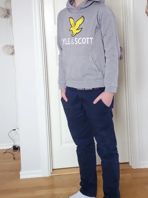En grå hoodie från Lyle &Scott - En snygg och bekväm hoodie från Lyle & Scott som jag säljer för att den börjar bli lite liten. Har några små fläckar på framsidan men som man enligt min syster "inte tänker på". 