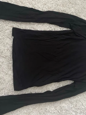 Svart långärmad spetsblus Vero Moda - Säljer en svart långärmad blus från Vero Moda i storlek M. Toppen har fina spetsdetaljer vid halsringningen och ärmsluten, använd 1 gång 