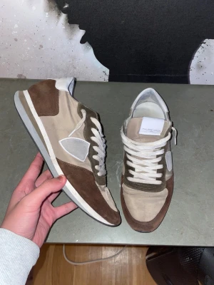 Philippe Model sneakers beige och bruna - Snygga Philippe Model sneakers i beige och brunt med vita detaljer. Skorna har snörning, rund tå och platt sula. Skorna är i bra skick. 