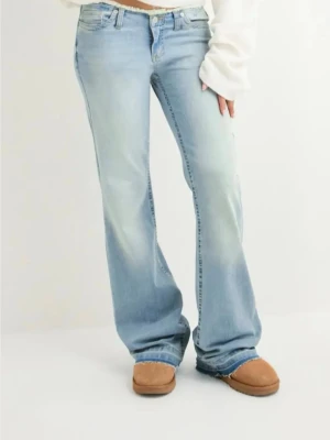 Bootcut low waist ljusblå jeans - Säljer ett par ljusblå bootcut jeans med rå, fransig kant längst ner. Jeansen har klassisk femficksdesign och är tillverkade i mjukt denimtyg. Storlek 36 från Nelly. 