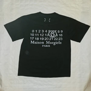 Maison Margiela t-shirt - Svart Maison Margiela t-shirt med tryck på ryggen || Storlek S 