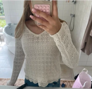 Vit virkad stickad tröja med v-ringning - Vit stickad tröja från Isolde i storlek S. Jag skulle mer beskriva tröjan som en ”dra över” tröja. Eftersom den är stickad behöver man ha något under. Perfekt till över linnen eller badkläder!  Använd fåtal gånger, ny skick!