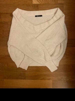 Vit stickad croppad tröja Gina Tricot - Superfin vit stickad tröja från Gina Tricot i croppad modell. Tröjan har v-ringning, långa ärmar och ribbade muddar. Perfekt för lager-på-lager och passar till både jeans och kjol. Enkel och stilren design som funkar året runt.