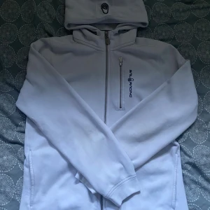 Vit Sail Racing Fullzip - Vit fullzip från Sail Racing i storlek 176 - sitter som S.   Knappt använd och därmed är den i väldigt bra skick. Nypris: 1500kr. Mitt pris: 299kr