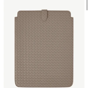 Beige datorväska i flätat skinn - Stilren beige datorväska från bouinr i flätat skinn. Slimmad design med smart knappstängning upptill. Perfekt för dig som vill ha en snygg och praktisk sleeve till laptopen. Passar till de flesta laptops och surfplattor.