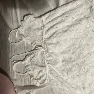 Vit spetsklänning med knytband - Hej jag vill sälja min tröja från lager 157 den är bara använd 3 gånger den är nästan ny Superfin vit topp med broderad spets och smala axelband. Tröjan har knytband i midjan och volangdetaljer vid axlarna. Perfekt för sommarens alla tillfällen och ger en romantisk vibe.