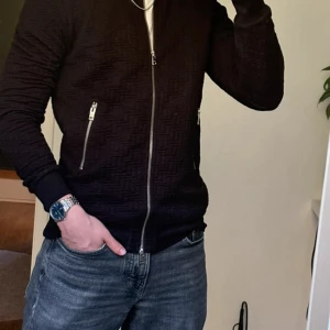 Svart overshirt från J.Lindeberg med dragkedja - Säljer en svart kofta från J.Lindeberg i storlek S. Tröjan har snyggt strukturerat mönster, hel dragkedja framtill och två fickor med dragkedjor. Mycket bra skick, inga defekter, sparsamt använd! Storlek: S. Säljer endast för 349. Tveka inte att höra av er med prisförslag eller funderingar!