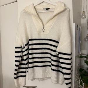 Randig stickad tröja med half zip Esmara - Supermysig stickad tröja från Esmara i vitt med svarta ränder. Oversized fit, ribbade muddar och cool krage med half zip och ringdetalj. Perfekt för höst och vinter när du vill vara både varm och snygg.