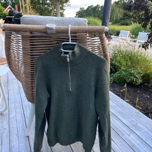 Mörkgrön stickad tröja med half zip - Snygg mörkgrön stickad tröja med halv dragkedja i halsen. Tröjan har lång ärm och ribbade muddar vid ärmslut och nederkant. Perfekt för kyliga dagar och enkel att matcha med jeans. Bra kvalitet och tyg. Pris: 249kr men ej hugget i sten