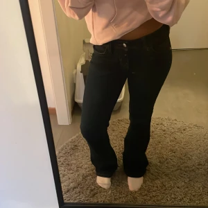 mörkblåa jeans - low waisted mörkblåa jeans med brun/guld söm från hm i storlek 34. knappast använd.  finns detaljer på fickorna. de är strechiga och bekväma.