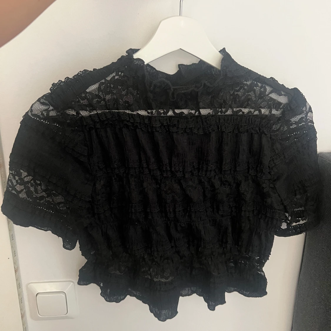 Svart spetsblus med volangdetaljer