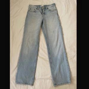 Ljusblå raka jeans från Zara - Säljer ett par ljusblå jeans från Zara i rak modell. Jeansen har klassisk femficksdesign, knappgylf och är tillverkade i bomull. Perfekta för en avslappnad och trendig look.