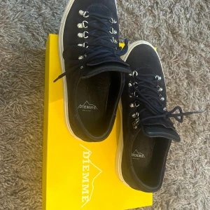 Diemme - Mörkblå mockasneakers - Diemme sneakers strl 42. Köpta i slutet av juli i år och i riktigt bra skick (9/10). Exklusiv modell i mörkblå mocka med vita sulor och robusta metallhakar för en unik och lyxig känsla. Endast sparsamt använda. Skorna håller högsta italienska kvalitet och nypriset ligger betydligt högre. Originalkartong medföljer. Hög efterfrågan. Perfekt för dig som vill ha stilrena och hållbara sneakers. Kika gärna in mina andra annonser, bättre pris kan ordnas vid köp av flera varor. Snabb affär prioriteras!