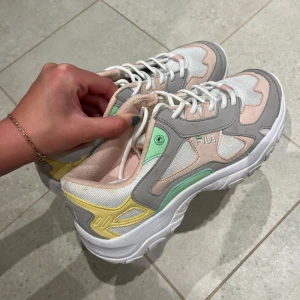 Pastellfärgade sneakers från Fila - Chunky sneakers från Fila i en snygg mix av pastellfärger: vitt, ljusrosa, mintgrönt, gult och grått. Nypris: 900kr