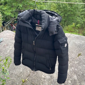 Moncler Montgenevre Jacka - Riktigt snygg Moncler Montgenevre i väldigt mysigt ull. Rättså fint skick små defekter finns. Den är äkthets kollad och jag har certifikat.  Storlek 3 passar dig runt 170-180 bra. Nypris på denna ligger på 24000. Skicka gärna bud. Mvh 