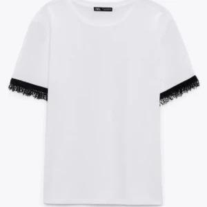 Vit t-shirt med pärlor från Zara - Vit t-shirt från Zara med korta ärmar och svarta pärlor vid ärmarna. Använd så att några pärlor lossnat men det synns knappt