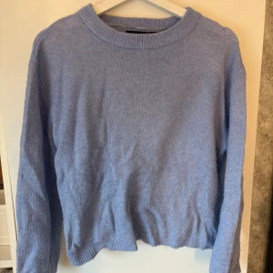 Ljusblå stickad tröja från 157 - Superfin ljusblå stickad tröja från 157 i storlek XS. Tröjan har rund halsringning, ribbade muddar och är långärmad. Perfekt för lager-på-lager och chill dagar. Enkel och stilren design som passar till det mesta.