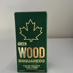 DSQUARED2 Green Wood Eau de Toilette - Green Wood Eau de Toilette från DSQUARED2 för herrar, 50 ml. Flaskan är mörkgrön med svart träliknande kork och guldiga detaljer. Förpackningen är grön med ett guldigt lönnlöv och text. Fräsch och träig doft med citrus och blommiga inslag. pris kan diskuteras
