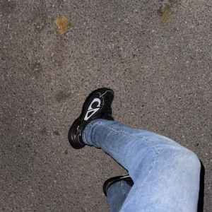 Svarta Dior B30 sneakers - Säljer ett par svarta Dior B30 sneakers med reflekterande silverdetaljer och tydlig Dior-logga på sidan. Skorna har en chunky sula, meshpaneler och snygga linjer i syntetmaterial. Perfekta för dig som gillar exklusiva och trendiga sneakers.