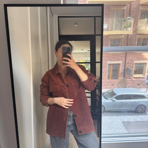 Brun manchester overshirt Selected Homme - Säljer en brun overshirt från Selected Homme i grov manchester. Jackan har stora bröstfickor med lock, klassisk krage och svarta knappar framtill. Passformen är loose och den är perfekt att slänga över en t-shirt eller hoodie.