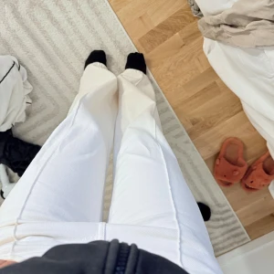 Vita wide jeans med raka ben - Säljer ett par vita jeans med bred passform och raka ben. Byxorna har låg midja, klassiska femficksdetaljer och markerade sömmar framtill. Jeansen är från Ginatricot.