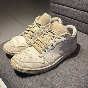 Nike Jordan 1 Low  - Säljer ett par välanvända Nike Jordan 1 Low. Skorna har perforerad tå, snörning och låg siluett. Materialet är en mix av slätt och texturerat skinn.