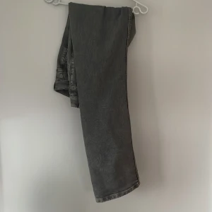 Grå jeans från Montén 32/32 - Snygga grå jeans från Montén i klassisk femficksmodell. Jeansen har raka ben, normal passform och coolt tvättad look. Perfekta för dig som gillar en stilren vibe med lite edge. Materialet är slitstarkt denim och färgen är en mörkgrå nyans.