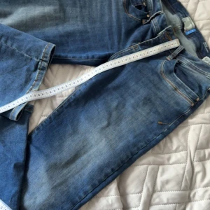 Blå bootcut jeans låg midja - Säljer ett par blå jeans från LTB med snygg bootcut och låg midja. Jeansen har klassisk femficksdesign, ljus tvätt och subtila slitningar. Perfekta för dig som gillar en avslappnad men ändå trendig look.