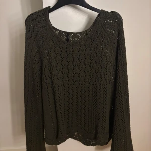 Mörkgrön stickad tröja från Only - Säljer en mörkgrön stickad tröja från Only med snyggt hålmönster och rund halsringning. Använd fåtal gånger