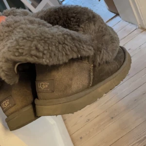 Gråa UGGs  - Mysiga gråa  UGG boots med tjockt fårskinnsfoder och uppvikbar kant. Klassisk rund tå och platt sula, perfekta för kalla dagar. Väl använda