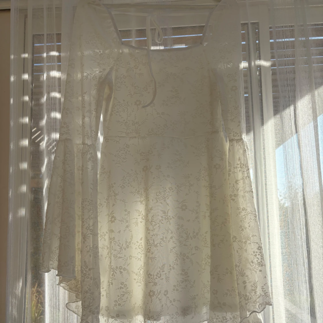 Vit blommig kortklänning med trumpetärm - 1