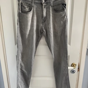 Replay Anbass - Snygga grå jeans från Replay med raka ben och klassisk femficksdesign. Jeansen har svarta kontrastsömmar och diskret Replay-logga på fickan. Perfekta för dig som gillar en stilren och avslappnad look.