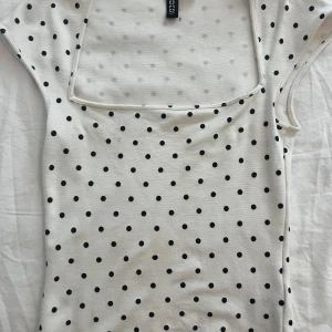 Vit prickig topp från H&M Divided - Supersöt vit topp från H&M Divided. Säljer då den blivit förliten.