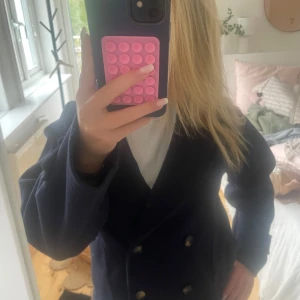 Mörkblå skepparkavaj från RYVLS - Säljer en klassisk mörkblå skepparkavaj från RYVLS med dubbelknäppning och bred krage. Jackan har snygga knappar framtill och uppvikta ärmslut. Perfekt för dig som gillar en tidlös och stilren look. Aldrig använd💞