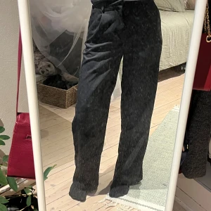 Svarta vida kostymbyxor - Snygga svarta kostymbyxor med hög midja och vida ben. Byxorna har klassiska pressveck och hällor för bälte. Materialet känns mjukt och har en lätt stretch 💕