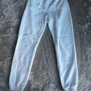 Vita mjukisbyxor med resår - Snygga vita mjukisbyxor med resår i midjan och vid bensluten. Byxorna är i mjukt bomullsmaterial och har en relaxed passform som är perfekt. Knappt använda 