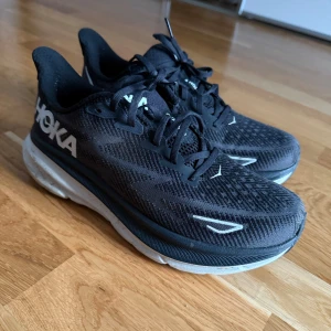 Svarta Hoka sneakers med tjock sula - Säljer ett par svarta Hoka sneakers med vit och svart tjock sula. 