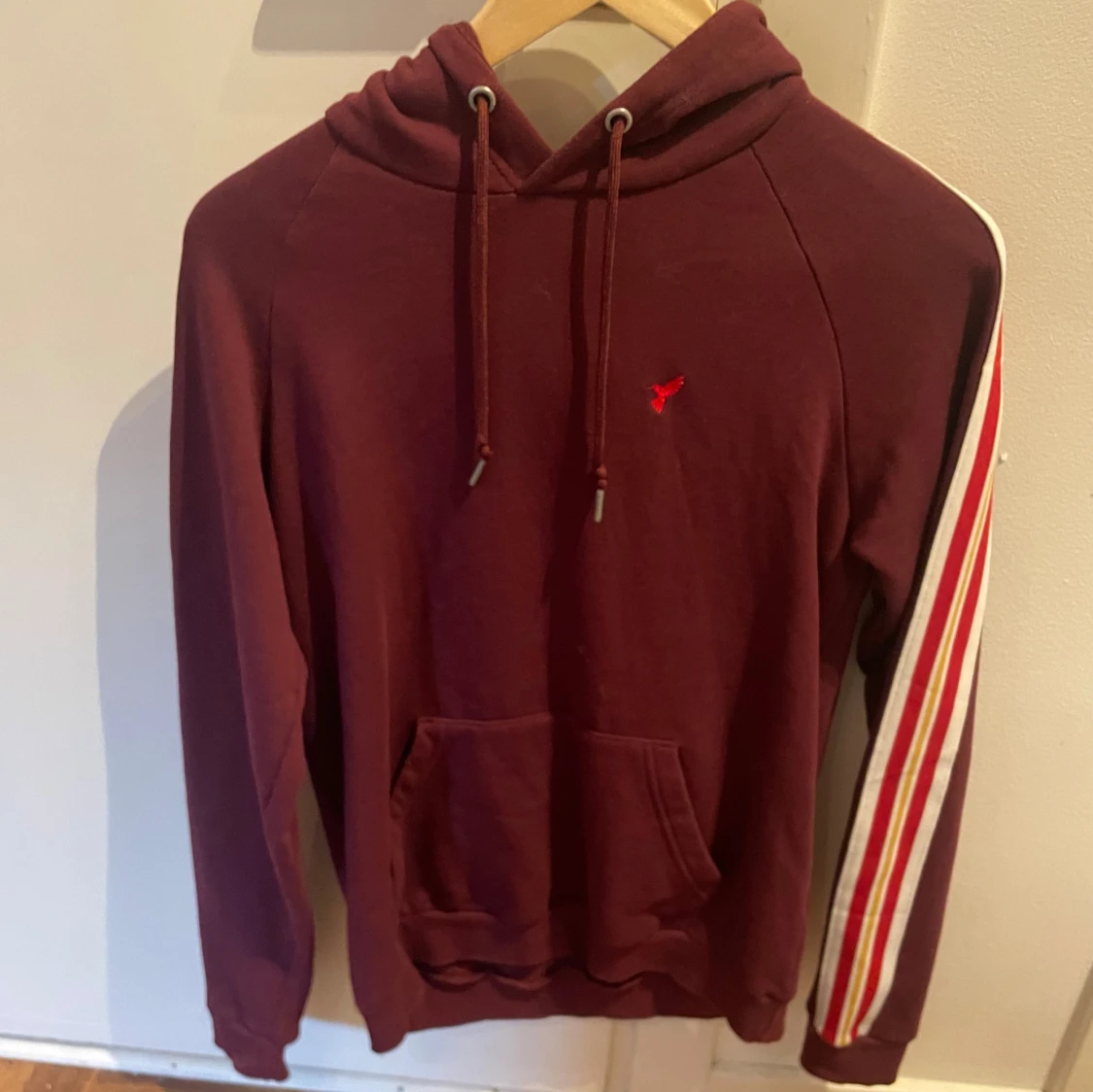 Vinröd hoodie med ränder på ärmen