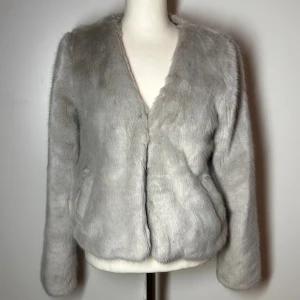 Pälsjacka  - Pälskappa med fickor i storlek xs. Grå/beige. (Fuskpäls) köp sker via köp nu, jag postar inom 24h. Kvar tills markerad såld 