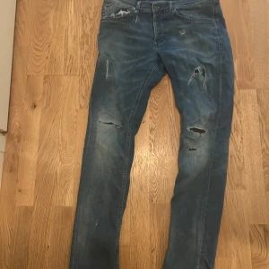 Dondup George  - Säljer nu dessa dondup george med slitningar. Jeansen har klassisk femficksdesign och är tillverkade i ett mjukt denimtyg. Perfekta för dig som gillar en edgy och trendig look. Hör av er vid frågor!