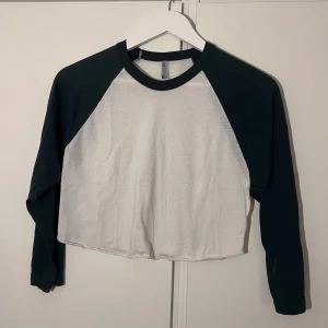 Vit och mörkgrön trekvarts tröja - Vit och mörkgrön trekvarts tröja från American Apparel. Klassisk baseballmodell med croppad passform. 