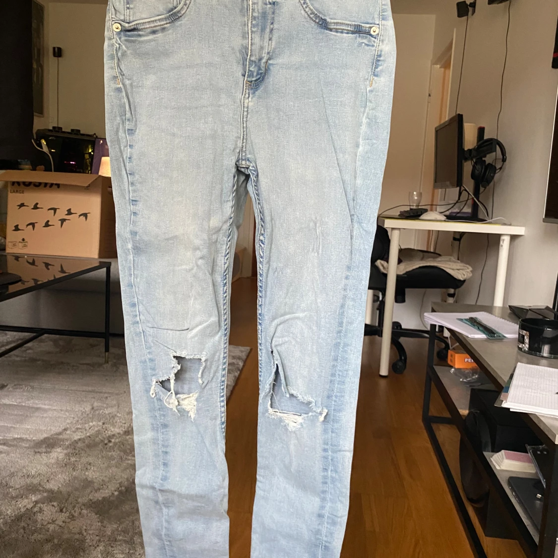 Ljusblå slitna jeans med hål