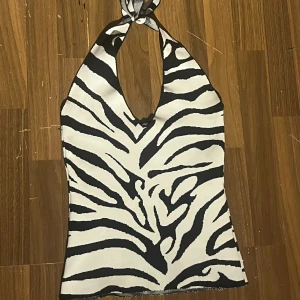 Zebramönstrad halterneck topp S - En snygg zebramönstrad halterneck top, storlek S men relativt stretchig så lite M också.             Säljer även den på Vinted för samma pris! (mirabellesimonsson)  (kan fixa slutet så det ser snyggare ut om det önskas men så som den är nu så kommer trådarna inte gå upp/toppen förstöras)  Pris går alltid att diskuteras! 💗