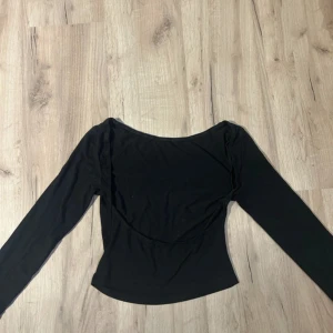 Gina tricot öppen rygg tröja  - En svart långärmad topp med öppen rygg . Tunn och stretchig i materialet, perfekt att styla med jeans eller kjol. Enkel och stilren design.