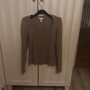Beige långärmad topp från H&M XS - Snygg beige långärmad topp från H&M i storlek XS. Modellen har rund halsringning och är figurnära med enkel design. Perfekt att styla med jeans eller kjol för en clean look. Materialet känns mjukt och lätt mot huden.