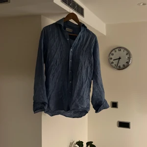 Blå linneskjorta från John Henric - Snygg blå skjorta från John Henric i luftig linnematerial. Den är använd ca 4 gånger och är i nyskick. Nypris 999kr pris kan diskuteras 