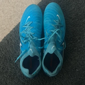 Blå Nike fotbollsskor phantom  - Säljer ett par blå Nike phantoms pro dom är i väldigt bra skick och har inte används mycket. Jag säljer dom för jag har slutat i fotboll
