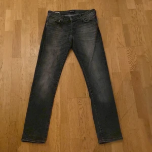 Svarta slim jeans Jack & Jones (Glenn) - Snygga svarta slim fit jeans från Jack & Jones, modell Glenn. Riktigt feta och sitter bra på benen, tyvärr har lappen spruckit som man kan se på sista bilden. Inte så jätte stor grej för att det går att klippa bort den om man känner för det!