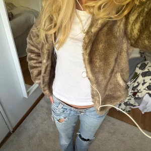 Brun pälsjacka med ribbade muddar - Säljer en snygg brun pälsjacka med mjuk, fluffig känsla och ribbade muddar vid ärmslut och midja. Jätte mysig och gosig nu till hösten när det blir lite kallare! Hör gärna av er vid frågor eller intresse💕